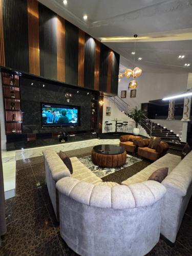 a living room with a large couch and a tv at D5 future homes hotel & apartment in Benin City
