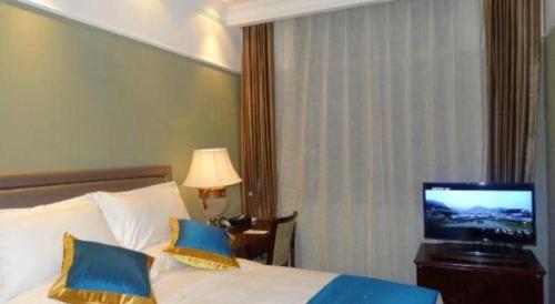 a hotel room with a bed and a television at Datong Hotel in Datong