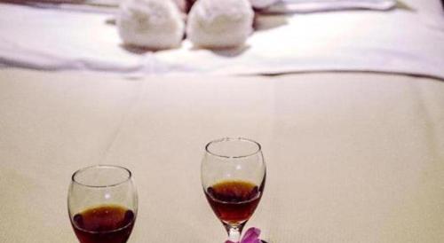 two glasses of wine sitting on a table at New Friendship Hotel in Luoyang