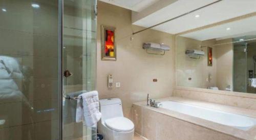 a bathroom with a tub and a toilet and a shower at Hohhot Hai Liang Plaza Hotel in Hohhot