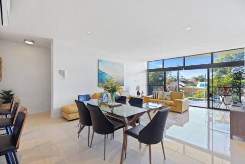 Un comedor con una mesa de cristal y sillas. en Aqua Shores - 1 Bedroom couples stay - Wifi, Linen, Netflix and AC, en Huskisson