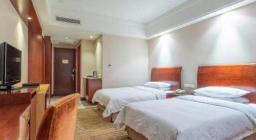 a hotel room with two beds and a flat screen tv at Hohhot Hai Liang Plaza Hotel in Hohhot