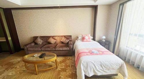 a room with a bed and a couch and a table at Hohhot Hai Liang Plaza Hotel in Hohhot