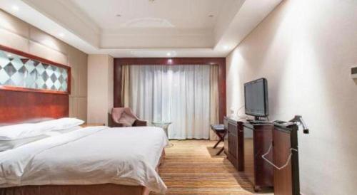 a hotel room with a bed and a television at Hohhot Hai Liang Plaza Hotel in Hohhot