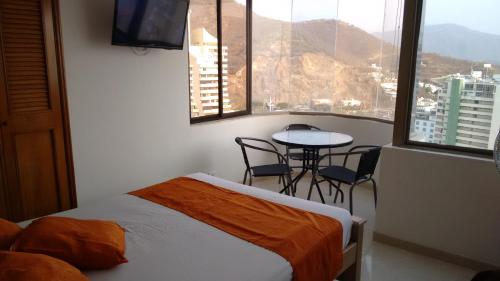 a room with a bed and a table with a view at CYM Arriendos 1605 in Santa Marta