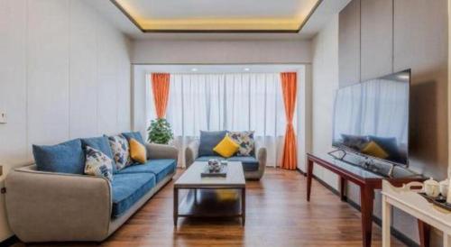 a living room with a blue couch and a tv at Movie Star Hotel in Guangzhou