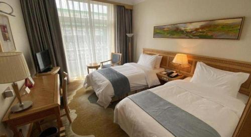 a hotel room with two beds and a television at Beijing Friendship Hotel Jing Bin Building in Beijing