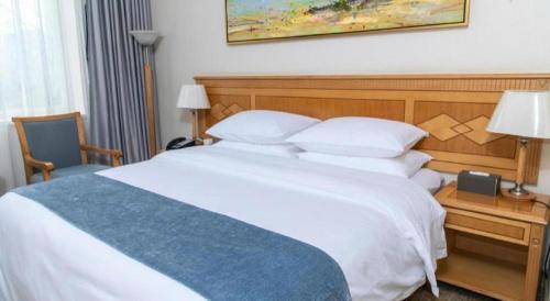 a bedroom with a large white bed and a desk at Beijing Friendship Hotel Jing Bin Building in Beijing
