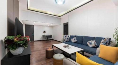 a living room with a blue couch and a table at Movie Star Hotel in Guangzhou