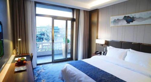a hotel room with a bed and a large window at Beijing Friendship Hotel Jing Bin Building in Beijing
