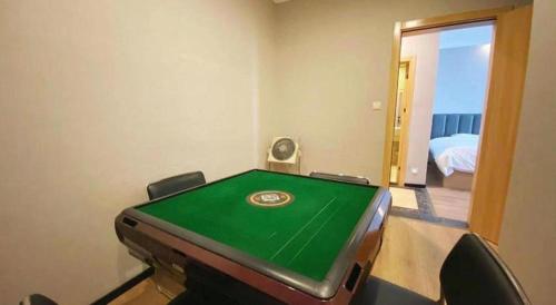 a room with a pool table in a room with a bed at GreenTree Inn Taizhou New District Hospital of Renmin Hospital Mingliu Express Hotel in Jiuligou