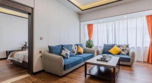 a living room with a blue couch and a bed at Movie Star Hotel in Guangzhou
