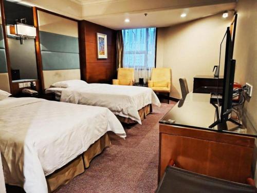 a hotel room with two beds and a flat screen tv at Linyi Blue Horizon Intenational Hotel in Linyi
