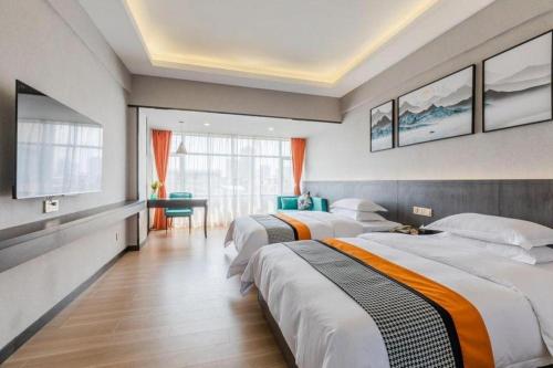 a hotel room with two beds and a television at Movie Star Hotel in Guangzhou
