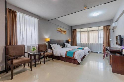 a hotel room with a bed and a table and chairs at Movie Star Hotel in Guangzhou