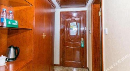a kitchen with a wooden door in a room at GreenTree Alliance Zhejiang Zhoushan Putuoshan Zhujiajian Scenic Spot Hotel in Zhoushan