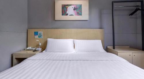 Ein Bett oder Betten in einem Zimmer der Unterkunft Jinjiang Inn Wenzhou Shuangyu The Terminal