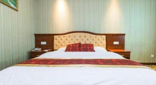 a bedroom with a large bed with a red pillow at GreenTree Alliance Zhejiang Zhoushan Putuoshan Zhujiajian Scenic Spot Hotel in Zhoushan