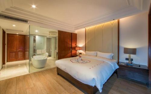 a bedroom with a large bed and a bath tub at Hainan Yatai Hot Spring Hotel in Haikou
