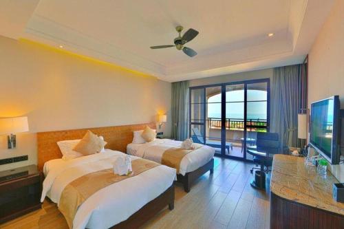 a hotel room with two beds and a television at Hainan Yatai Hot Spring Hotel in Haikou