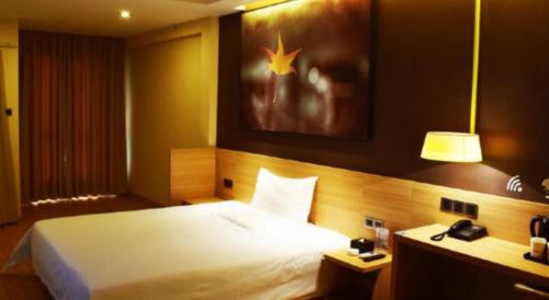 a hotel room with a large bed and a telephone at IU Hotel Chengdu High-Tech Zone Longhu Times Street in Chengdu