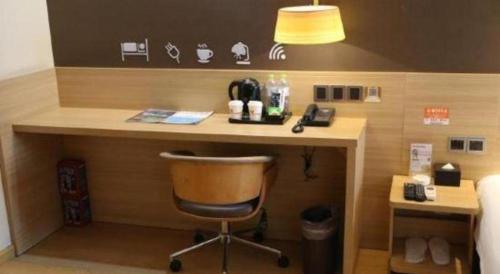 a desk in a hotel room with a chair at IU Hotel Chengdu High-Tech Zone Longhu Times Street in Chengdu