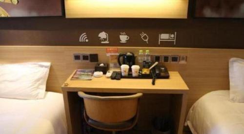 a hotel room with a desk with a chair next to a bed at IU Hotel Chengdu High-Tech Zone Longhu Times Street in Chengdu