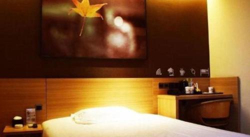 a bedroom with a bed with a wooden head board at IU Hotel Chengdu High-Tech Zone Longhu Times Street in Chengdu