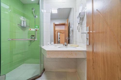 a bathroom with a sink and a shower at GreenTree Inn Haixi Geermu Southern suburbs Express Hotel in Golmud
