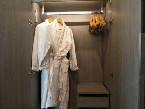 a white robe is hanging in a closet at Jinjiang Metropolo Hotel - Turpan Administration Center in Turfan