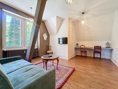 un salon avec un canapé et une table dans l'établissement Sahler Duplex 20th-Century Château, à Exincourt