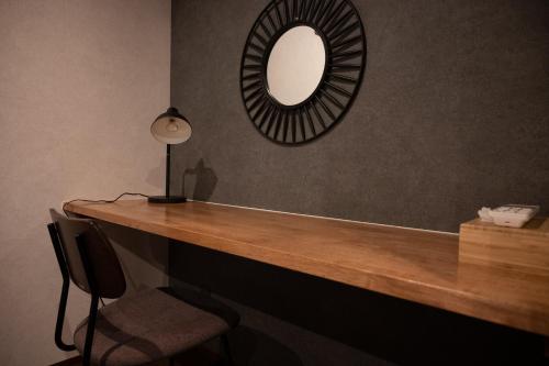 a mirror and a desk with a chair and a lamp at Zenya-Nakano in Nakano