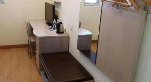 a small kitchen with a desk and a refrigerator at Thank Inn Hotel Hebei Langfang Xianghe County Guidu Furniture Center in Jinxinzhuang