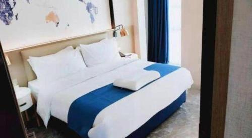 a white and blue bed in a hotel room at Kyriad Marvelous Hotel Xiangyin Bus Station in Xiangyin