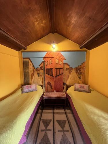 two beds in a room with a painting on the wall at Joy Source Resort in Kathmandu