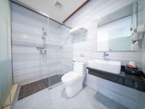 ein Badezimmer mit Toilette, Waschbecken und Dusche in der Unterkunft Jun Hotel Guangxi Wuzhou Changzhou District Fengye Garden in Wuzhou