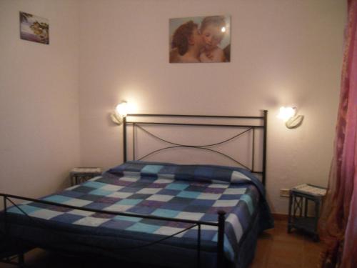 a bedroom with a bed and two pictures on the wall at Appartamento MareMontagna in Cardedu