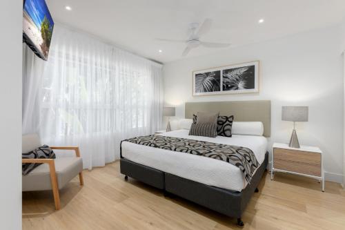 a bedroom with a large bed and a window at Mandalay Luxury Beachfront Apartments in Port Douglas