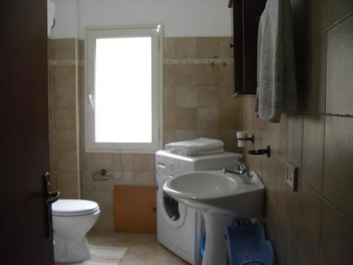 a bathroom with a sink and a washing machine at Appartamento MareMontagna in Cardedu