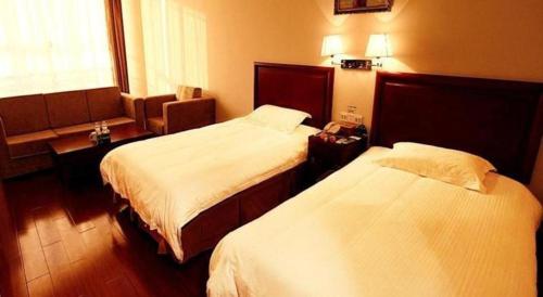 a hotel room with two beds and a window at GreenTree Inn Rizhao Yantai Road in Rizhao