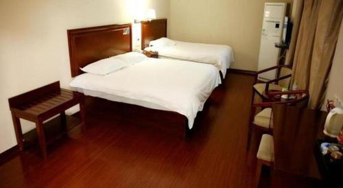 a bedroom with two beds and a wooden floor at GreenTree Inn Rizhao Yantai Road in Rizhao