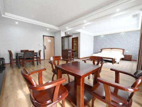 a living room with a table and chairs and a bed at GreenTree Inn Gaoyou Government in Yangzhou