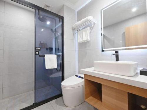 a bathroom with a shower and a sink and a toilet at GreenTree Inn Gaoyou Government in Yangzhou