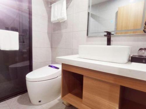 a bathroom with a toilet and a sink and a shower at GreenTree Inn Gaoyou Government in Yangzhou
