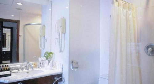 a bathroom with a sink and a shower with a mirror at Datong Tiangui International Hotel in Datong