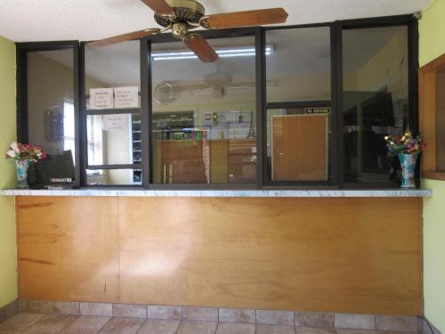 a restaurant counter with windows and a ceiling fan at Town House Motel in Tyler