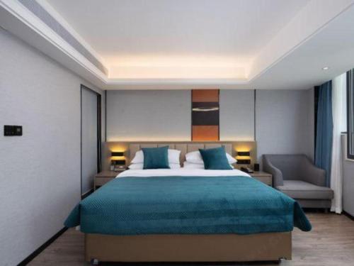 a bedroom with a large bed with blue sheets at Nanning Prince Hotel in Nanning