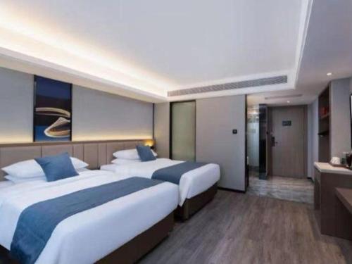 a hotel room with two beds and a bathroom at Nanning Prince Hotel in Nanning