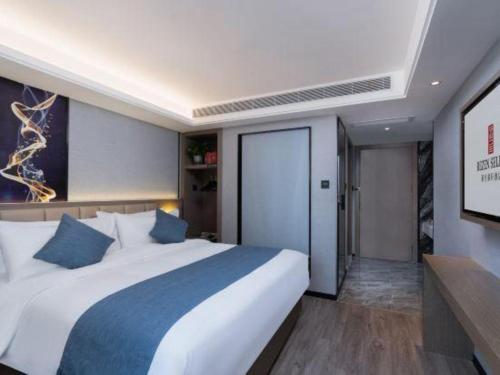 a bedroom with a large white bed with blue pillows at Nanning Prince Hotel in Nanning