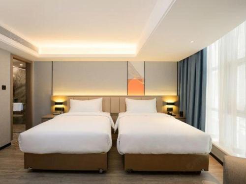 two beds in a hotel room with two beds sidx sidx sidx at Nanning Prince Hotel in Nanning